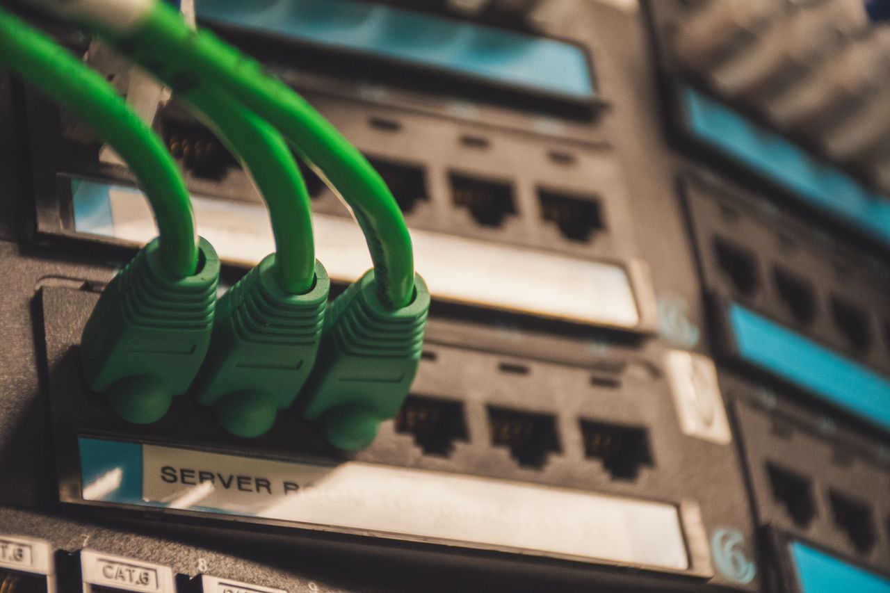 The Art of Drawing Readers In: Your attractive post title goes here Close-up of green network cables plugged into server ports, showcasing technology setup.