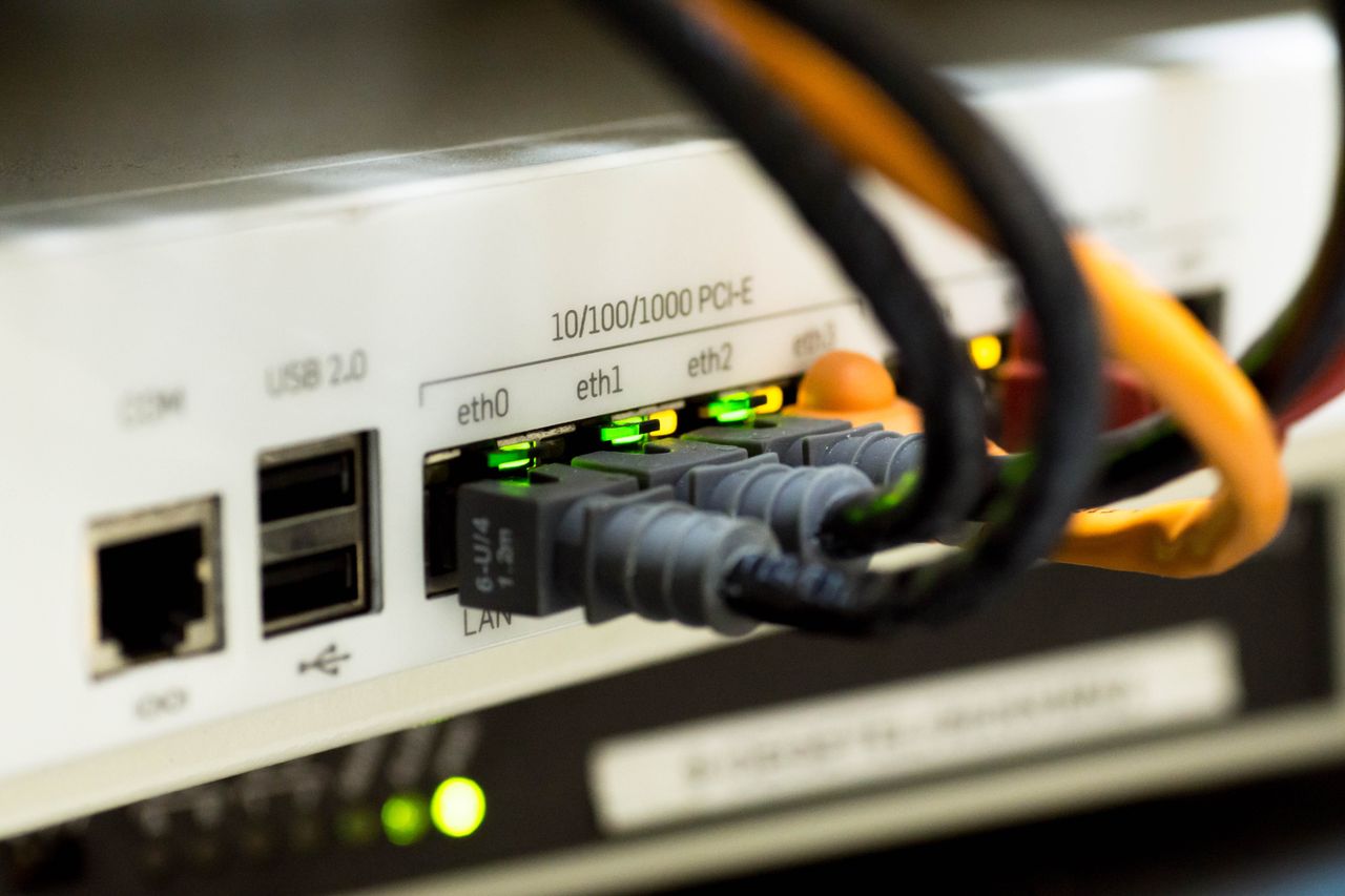 heros-img Detailed close-up of ethernet cables and network connections on a router, showcasing modern technology.